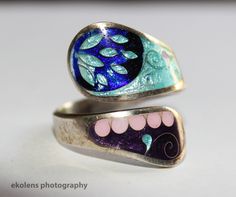 This ring is one of its kind. Hand-made in Eastern Europe (Georgia), this ring has the finest, smooth enamel finish to the blue-and-purple theme, lodged in the best quality 925 silver base. Makes for a great birthday, graduation, holiday, or anniversary gift.   Weight: 7.3 grams Ring size: 8.5 (U.S.); 18.5 (U.K.) Material: 925 silver Finish: Enamel (smooth, 3-D effect) Ships via UPS.  Contact us any time with questions! Unique Open Enamel Ring For Anniversary, Artistic Hand Painted Silver Rings, Unique Adjustable Enamel Ring, Blue Enamel Round Rings, Adjustable Enamel Round Ring, Adjustable Enamel Ring Jewelry, Adjustable Round Enamel Ring, Adjustable Enamel Ring, Silver Enamel Open Ring