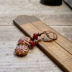 These colors just drew me in! They are so rich and beautiful together. I now have a whole selection of beads that will mix and match with this series. When I look at these, I initially think fall or autumn, then I gravitate to considering Christmas. These items are all available with antique brass or copper. Every earring is available with titanium ear wire, if you need them for your sensitive ears. Even if you don't need them, they look and feel great. These long dangle earrings are perfect for Handmade Artisan Red Earrings, Red Drop Clip-on Earrings As Gift, Red Drop Clip-on Earrings For Gift, Red Dangle Clip-on Earring, Red Dangle Single Clip-on Earring, Artisan Red Dangle Earrings, Nickel-free Red Drop Earrings Jewelry, Artisan Red Pierced Jewelry, Artisan Red Drop Earrings