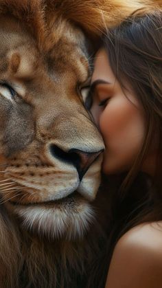 a woman is kissing a lion with her face close to it's face,