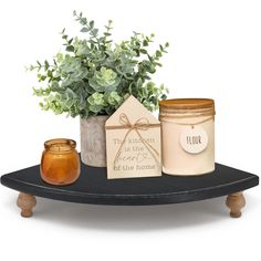 a potted plant sitting on top of a table next to two jars with labels