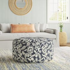 a living room filled with furniture and a large round mirror on the wall above it