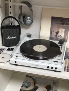 a record player sitting on top of a white shelf