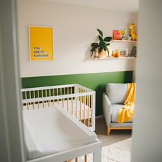 a baby's room with green and white walls