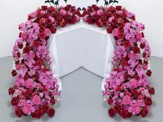 an arrangement of pink and red flowers arranged in the shape of a heart