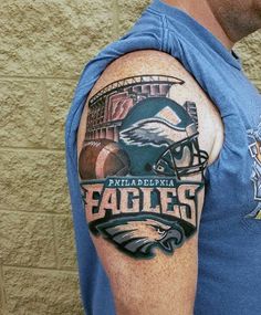 a man with a philadelphia eagles tattoo on his arm