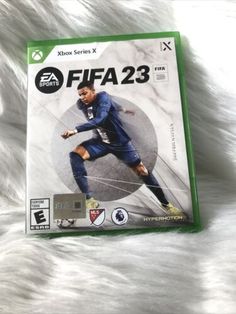 the box art for the xbox version of the video game soccer is displayed on a white fur surface