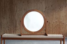 a mirror sitting on top of a wooden bench