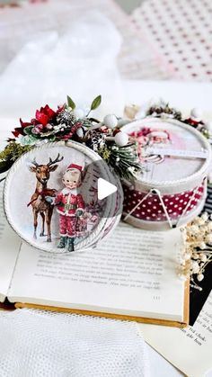 an open book sitting on top of a table covered in christmas decorations and paper work