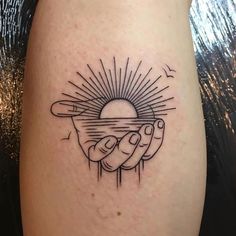 a tattoo on the leg of a person holding a hot dog in their hand with sun and clouds above it