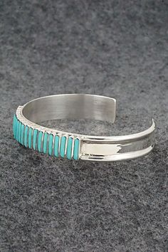 This turquoise and sterling silver bracelet was made by Zuni silversmith Lucy Sheyka. The back is signed LS, Zuni and stamped sterling.Size: 5 1/4" (will fit up to a 6 1/4" wrist)Gap: 1"Width: 3/8"Free shipping on all orders! We ship with USPS and always include tracking. All orders ship within a day of payment.Returns are accepted up to 30 days after you receive your order. Just send us a message. Our shop offers cash back or store credit. The item must be returned in new condition. Adjustable Blue Cuff Bracelet Stamped 925, Artisan Turquoise Sterling Silver Bracelet, Artisan Adjustable Blue Sterling Silver Bracelet, Artisan Sterling Silver Bracelet With Inlay, Handmade Turquoise Sterling Silver Bracelets, Unique Turquoise Sterling Silver Bracelets, Turquoise Sterling Silver Bracelet, Sterling Silver Turquoise Oyster Bracelet, Sterling Silver Blue Oyster Bracelet