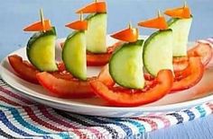 a plate topped with sliced tomatoes and cucumber boats on top of each other