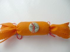 an orange stuffed animal laying on top of a white table next to a red string