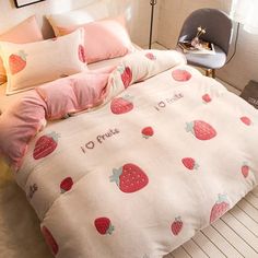 a bed with strawberry print and pink pillows