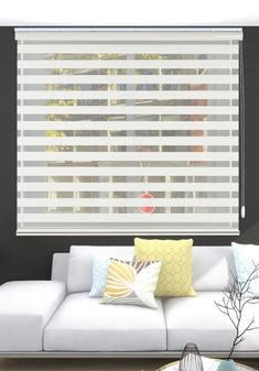 a white couch sitting in front of a window covered in blinds