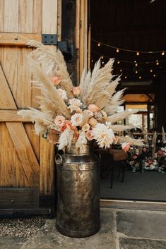 a vase filled with lots of flowers next to a wooden door