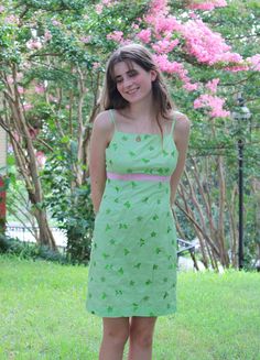 "This is a Lilly Pulitzer green mini dress with a pink ribbon that ties in the back. The dress has a zipper in the back in addition to the ribbon.The dress has an embroidered pattern of fruits and flowers such as cherries, lemons, and oranges. The dress is in perfect condition! The waist is 14 in (28\") laid flat and the length is 29.5 in. The dress best fits as a size women's small and is marked as a size 4. The model is a size small." Green Mini Dress For Picnic, Cute Green Square Neck Dress, Green Summer Mini Dress For Picnic, Casual Green Mini Dress For Picnic, Green Square Neck Dress For Picnic, Green Spring Picnic Dress, Green Summer Dress For Picnic, Cute Green Mini Dress For The Beach, Cute Green Mini Dress For Beach