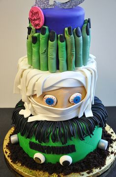 a birthday cake decorated to look like an elf with green hair and blue eyes is on a table