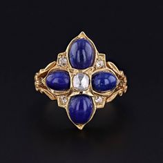 Antique Lapis Lazuli and Diamond Ring: Discover the exquisite charm of this antique ring dating back to the late 1800s.  The 15ct gold ring is adorned with four vibrant lapis lazuli cabochons interspersed with lively rose cut diamonds.   The face of the ring measures 0.9 inches from top to bottom by 0.7 inches wide, and it is in great condition. The ring is a size 6.5, but it can be resized free of charge. Upon purchase, your ring will arrive elegantly packaged, ready for gifting or as a special Christian Ring, Cross Christian, Ring Elegant, Alexandrite Ring, Lapis Lazuli Ring, Antique Ring, Locket Charms, Tiny Diamond, 18k Gold Ring