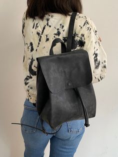 "This drawstring backpack is made of high quality vegan leather in black. It is very soft and lightweight but durable. It has a rustic, distressed look. t is water resistant. It can be used as diaper bag. It has one interior and one exterior zipper pocket. Straps are adjustable. It is suitable for both men and women. There is two size option: Small : 17 x 27 x 30 cm Large : 20 x 30 x 36 cm IMPORTANT! // Please add your phone number to the notes section before checkout. //  Delivery takes 2-5 day Vegan Leather Backpack, Black Leather Backpack, Black Vegan, Leather Gifts, Diaper Backpack, Distressed Leather, Backpack Purse, Black Backpack, Beautiful Bags