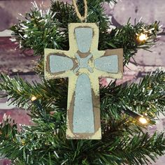 a wooden cross ornament hanging from a christmas tree