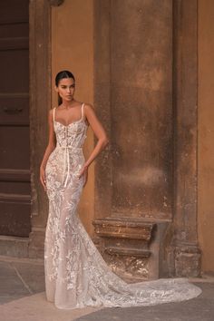 a woman standing in front of a building wearing a wedding dress