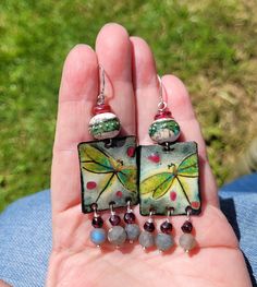 a person holding some kind of earrings in their hand with beads on the outside and inside