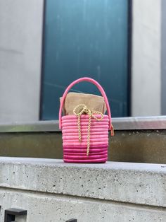 Our much loved Leandra bag comes now also in sweet candy colors, which are super special thanks to the natural shine of the fique fibers. It is handmade by Colombian artisans from Guacamayas in a traditional basketry technique of rolled dyed fibers of fica plants woven over straw fibers. The handbag is lined with a natural linen pouch finished with a golden rope drawstring and finished with the signature bronze Cuckoo B tag. We love to pair the Leandra bag with a flowy dress and flat sandals. Ma Linen Pouch, B Monogram, Traditional Baskets, Sweet Candy, Flowy Dress, Candy Colors, Natural Linen, Pink Bag, Decorative Wicker Basket