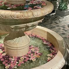 there is a fountain with flowers in it