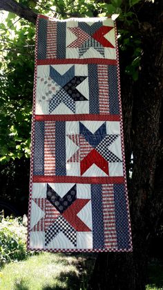 an american flag quilt hanging from a tree