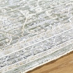 an area rug on top of a wooden floor with white and green colors in the middle