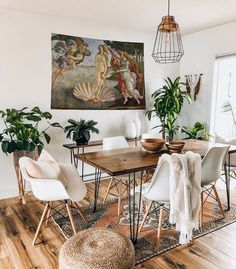 a dining room with white chairs and wooden table