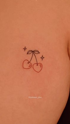 the back of a woman's stomach with two cherries and stars on it