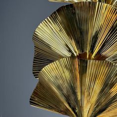 a gold sculpture is shown against a gray background with the light reflecting off it's side