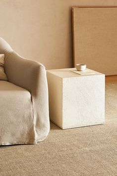 a chair and ottoman in a room with beige walls, carpeting and rugs