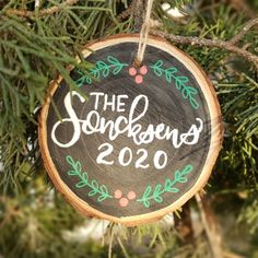 rustic wood slice ornament that says family last name and the year hand lettered in white with green and red leaf and berry doodles Diy Ornament Wood Slice, Painted Name Ornaments, Berry Doodles, Slice Ideas, Ornament Painting, Tree Cookies, Family Ornaments, Homemade Ornaments, Christmas Idea