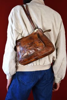 Step back in time with this authentic 1970s original brown leather shoulder bag, a vintage treasure that exudes timeless style and sophistication. Crafted from premium quality leather, this exquisite accessory has aged like fine wine, boasting a rich patina that only enhances its allure. The warm brown hue of the leather is reminiscent of a well-loved heirloom, inviting touch with its supple texture and visible grain that tells a story of decades past. The bag features a robust thick metal zippe Vintage Satchel Shoulder Bag For Everyday, Everyday Vintage Satchel Shoulder Bag, Vintage Crochet Shoulder Bag For Everyday, Retro Vintage Brown Soft Leather Bag, Mid-century Brown Shoulder Bag For Travel, Vintage Cognac Satchel Bag, Retro Vintage Brown Rectangular Shoulder Bag, Retro Cognac Shoulder Bag For Everyday Use, Retro Brown Satchel With Removable Pouch