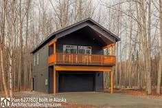 a two story house in the woods with an attached deck and garage on one level