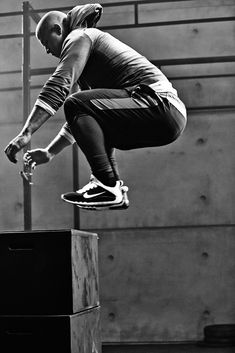 black and white photograph of a skateboarder doing a trick in the air with his board