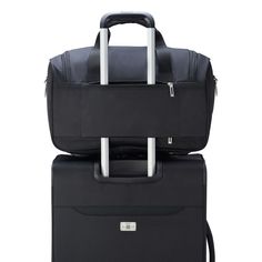 two pieces of luggage are stacked on top of each other, one black and the other white