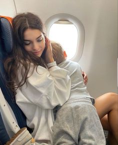 a woman is sitting on an airplane with her child