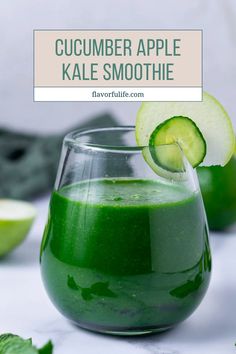 cucumber apple kale smoothie in a glass with a slice of cucumber