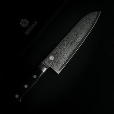 a large knife with intricate designs on it's blade is shown against a black background