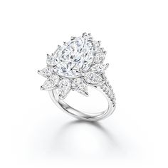 a ring with an oval cut diamond surrounded by smaller round and pear shaped diamonds on each side