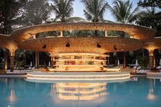 an outdoor bar with lights on the roof and palm trees in the backgroud