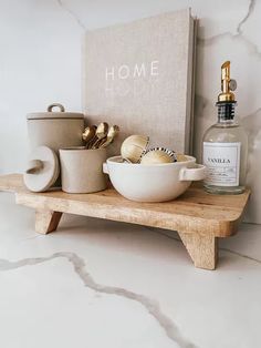 a wooden shelf topped with bowls and bottles next to a sign that reads home hold