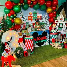 a mickey mouse themed birthday party with balloons and decorations on the wall, including balloon arch