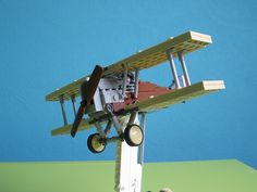 a small toy airplane on top of a wooden stand