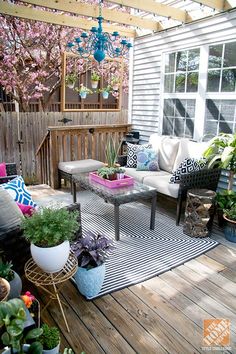 an outdoor patio with potted plants on the deck and table in the middle,