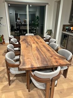 a large wooden table surrounded by white chairs