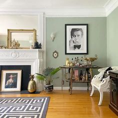 a living room filled with furniture and a fire place in front of a painting on the wall